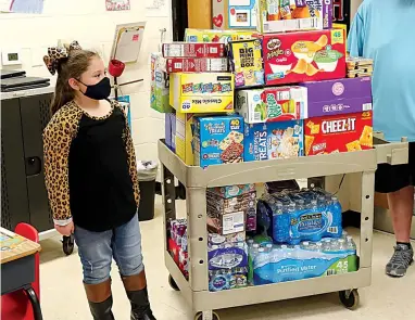  ?? The Sentinel-Record/Richard Rasmussen ?? Q Lakeside Intermedia­te School student Paisley Melancon, 7, with all the snacks she bought her classmates Friday.