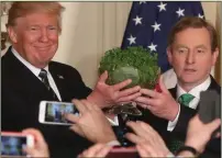  ??  ?? President Donald Trump receives his first bowl of south Kerry shamrock from Taoiseach Enda Kenny during the annual St Patrick’s Day visit to The White House.