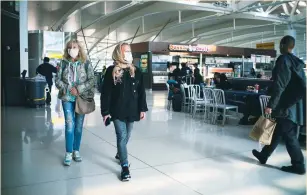  ?? (Eduardo Munoz/Reuters) ?? PEOPLE WALK at JFK Airport in New York on Saturday.