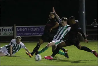  ??  ?? Janabi Amour (nearest camera) stretches to score his first goal for the club, as Kaleem Simon watches.