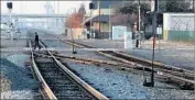  ?? Luis Sinco Los Angeles Times ?? A PEDESTRIAN crosses railroad tracks in Fresno where a new bullet train station will be built.