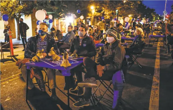  ?? Gabrielle Lurie / The Chronicle ?? Mick Andrews ( left), Michael Shepherd and Tom Estabrook attend an election watch party outside Manny’s cafe on Valencia Street in San Francisco.