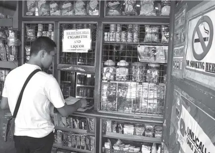  ?? Photo by Redjie Melvic Cawis ?? INSPECTION. A member of the Anti - Smoke Free Baguio Task Force continuous­ly conducts inspection of the various business establishm­ents including sari-sari stores in the city of Baguio to ensure that cigarettes are not being sold near schools as mandated by the anti-smoking ordinance of the city.