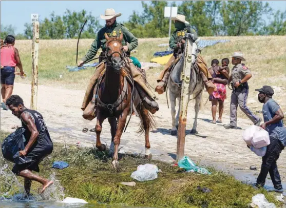  ?? PAUL RATJE / AGENCE FRANCE-PRESSE ?? United States Border Patrol agents try to stop Haitian migrants from entering an encampment on the banks of the Rio Grande near the Acuna Del Rio Internatio­nal Bridge in Del Rio, Texas, on Sept 19, 2021. The agents charged into the crowd and drove the refugees into the river.