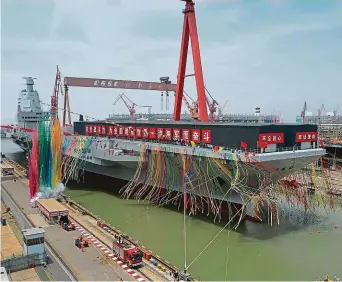  ?? ?? Tehdy a nyní. Vlevo třetí čínská letadlová loď Fu-ťien na snímku z června 2022, kdy byla v suchém doku v Šanghaji spuštěna na vodu, a vpravo aktuální fotografie z minulého pátku.