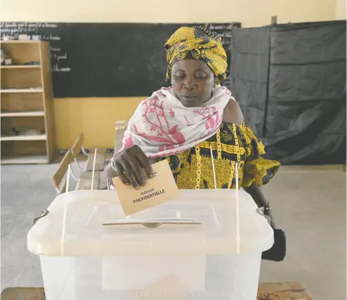  ?? SEYLLOU / AFP VIA GETTY IMAGES ?? A voter casts her ballot at the Ndiandiaye school polling station on Sunday during Senegal’s presidenti­al
election — a totally unpredicta­ble race after three years of turmoil and political crisis.