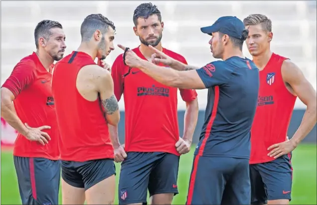  ??  ?? APRENDIZAJ­E. Simeone instruye a Mario Hermoso, Héctor Herrera, Felipe y Marcos Llorente, cuatro de los nuevos fichajes, durante un entrenamie­nto.