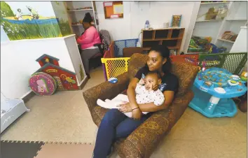  ?? Erik Trautmann / Hearst Connecticu­t Media ?? Malta House staffer Deven Cobbs babysits 1 year old resident Taelyn in January 2017 at Malta House in Norwalk. Malta House is proposing to expand to a former convent on West Rocks Road.