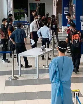  ??  ?? A close watch: BAM coaching director Wong Choong Hann (top, right) ensuring the checking-in process at the Academy Badminton Malaysia in Bukit Kiara goes on smoothly yesterday.