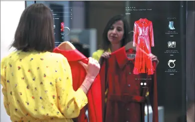  ?? BLOOMBERG ?? Sandrine Deveaux, managing director of Store of the Future, demonstrat­es the operation of a touch screen mirror to select fashion items at the launch of Farfetch UK Ltd.