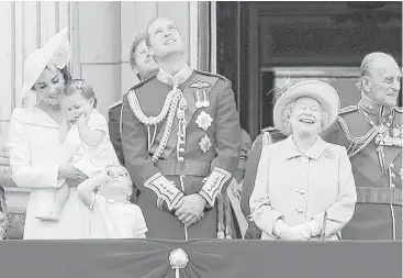  ?? Tim Ireland / Associated Press ?? Britain’s Queen Elizabeth II joins Prince Philip, right, Prince William, center, his son Prince George, front, and Kate, Duchess of Cambridge, holding Princess Charlotte, left, on the balcony during Saturday’s Trooping The Color parade at Buckingham...