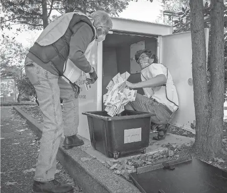  ?? ANDY NELSON/ USA TODAY NETWORK ?? Election workers David Campbell, left, and Matt Eva take ballots from a drop box in Oregon.