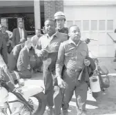  ?? AP 1963 ?? Revs. Ralph Abernathy, left, and Martin Luther King Jr. are taken by a policeman as they lead demonstrat­ors in a march to end racial segregatio­n in Birmingham, Alabama.