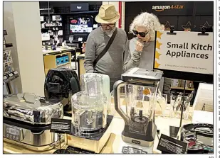  ?? AP ?? Shoppers browse items on display in September at the Amazon 4-star store in New York City. U.S. consumer confidence rose in October, the Conference Board says.