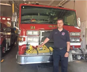  ?? SAMANTHA WEST / MILWAUKEE JOURNAL SENTINEL ?? Mike Zyniecki stands beside Engine 21.