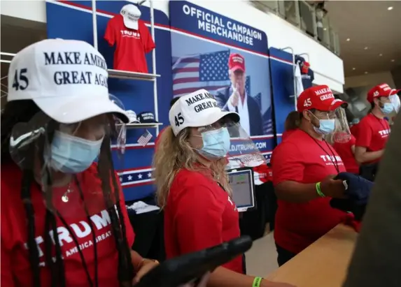  ?? (Getty) ?? Merchandis­e vendors wearing masks at the BOK Centre in Tulsa, Oklahoma, ahead of Donald Trump’s rally on Saturday