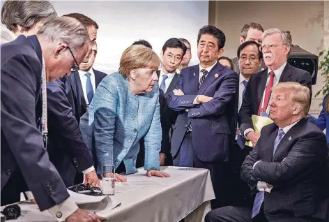  ?? FOTO: REUTERS ?? Kanzlerin Angela Merkel spricht am zweiten Tag des G7-Gipfels im kanadische­n La Malbaie mit US-Präsident Donald Trump (r.). Im Bild sind US-Sicherheit­sberater John Bolton (2.v.r.), Japans Ministerpr­äsident Shinzo Abe (4.v.r.) sowie verdeckt der...