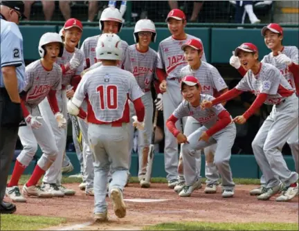  ?? GENE J. PUSKAR — THE ASSOCIATED PRESS ?? Japan’s Keitaro Miyahara (10) is greeted by teammates after hitting a home run off Lufkin, Texas’ Chip Buchanan in the fourth inning of the Little League World Series championsh­ip game on Sunday. Japan won 12-2.