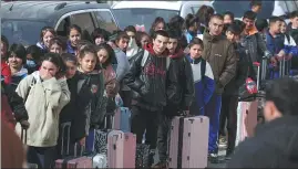  ?? ?? Left: Junior middle school students line up for their journey back to school last month.