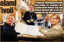  ??  ?? Freibergs Oberbürger­meister Sven Krüger (47, parteilos, M.)
überreicht Rommi (64) und Roland Säurich (66) in der Nikolaikir­che die Ehrenmedai­lle.