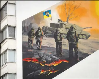  ?? (AP/Efrem Lukatsky) ?? A mural depicts volunteer soldiers of the 3rd assault brigade to honor the memory of their fellow soldier Serhiy Mashovets on an apartment building wall Feb. 1 in Kyiv, Ukraine. Mashovets was killed in 2022 defending capital Kyiv from Russian troops. He was an ecology activist who wanted to create a natural park in his home city district.
