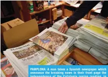  ??  ?? PAMPLONA: A man takes a Spanish newspaper which announce the breaking news in their front page the independen­ce of the Catalonia region reading, in Pamplona, northern Spain yesterday. — AP