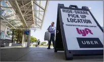  ?? ALLEN J. SCHABEN/LOS ANGELES TIMES ?? A traveler arrives in the ride-share pick up location at Ontario Internatio­nal Airport on Aug. 12, 2019 in California. Uber and Lyft will offer paid sick leave to drivers affected by COVID-19.