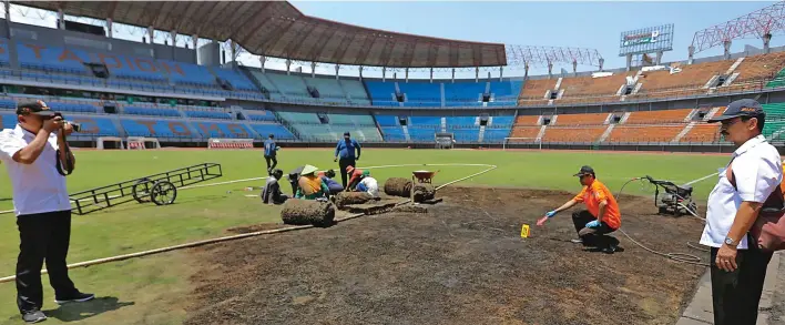  ?? PUGUH SUJIATMIKO/JAWA POS ?? SETELAH INSIDEN: Beberapa fasilitas yang rusak di Gelora Bung Tomo, Surabaya, mulai dibenahi kemarin. Di saat bersamaan, Tim Identifika­si Polda Jatim melakukan olah tempat kejadian perkara.