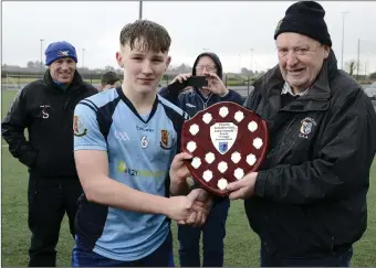  ??  ?? Dara Foy receives the Connacht Championsh­ip trophy from the Connacht Schools Chairman.