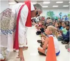  ??  ?? Colliervil­le Schools Superinten­dent John Aitken sings to Ella Shropshire, while performing as Elvis Presley during Immersion Day at Sycamore Elementary School. FILE/BRANDON