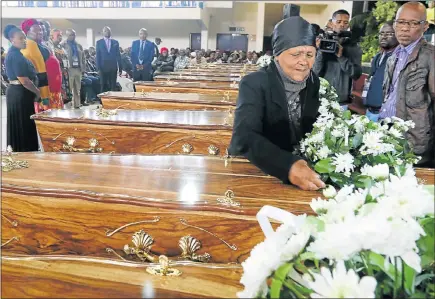  ?? Picture: FREDLIN ADRIAAN ?? BRINGING CLOSURE: Nomvula Gitywa places flowers on the coffin of her brother, Zwelidumil­e Mjekula, at yesterday’s ceremony to hand over the remains of 12 Eastern Cape UDF activists who were executed under the apartheid government