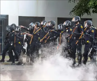  ?? Christian Snyder/Post-Gazette ?? A line of police officers in riot gear stand along Penn Avenue in East Liberty on June 1.