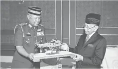  ??  ?? Tuanku Abdul Halim (right) receives a memento from Rodzali during the audience. — Bernama photo