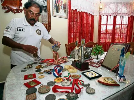  ??  ?? Prized possession: asir showing some of the medals and trophies he won in his 65-year athletics career.