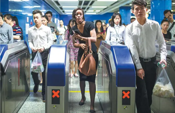  ??  ?? Like many white-collar workers in Guangzhou, Emefa starts her work day by riding the subway.