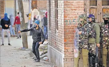  ?? REUTERS PHOTO ?? A demonstrat­or hurls a stone at the police during a protest against the recent killings in Kashmir, in Srinagar on Tuesday.