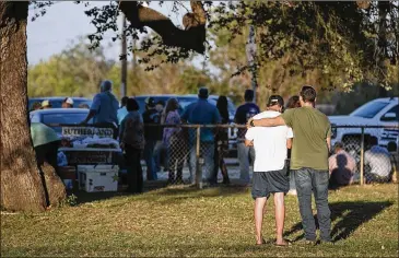  ??  ?? Two men comfort each other near the scene of the Sutherland Springs shooting last year. The FBI now responds to every active shooter situation in the United States, offering a wide range of resources and expertise to local authoritie­s.