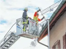  ?? FOTO: THOMAS WARNACK ?? Ein Teil des Schneefang­gitters auf dem Rathaus in Dürrenwald­stetten musste von der Feuerwehr entfernt werden.