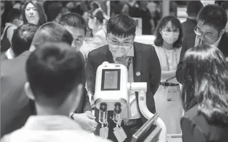  ?? PROVIDED TO CHINA DAILY ?? Visitors gather at the booth of Carestream Health Inc during a medical equipment exhibition in Shanghai in 2023.