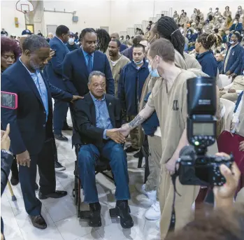  ?? SHANNA MADISON/CHICAGO TRIBUNE PHOTOS ?? The Rev. Jesse Jackson shakes hands with inmates at the Cook County Department of Correction­s on Saturday in Chicago.