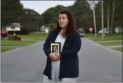  ?? HEATHER AINSWORTH — THE ASSOCIATED PRESS ?? Natalie Walters, 53, holds a photo of her parents, Jack and Joey Walters, near her home in Syracuse, N.Y., on Tuesday. Walters’ father, who was staying at the Loretto Health and Rehabilita­tion nursing home in Syracuse, died of COVID-19 in December 2020. The facility’s staffing has declined during the pandemic and Walters wonders if poor staffing played a role in her father’s infection or death.