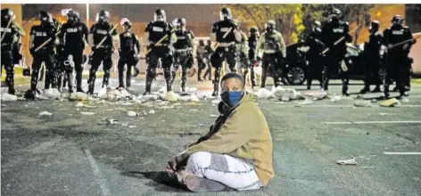  ?? FOTO: IMAGESPACE/IMAGESPACE VIA ZUMA WIRE/DPA ?? Ein Demonstran­t sitzt auf einer Straße vor einer Reihe von Bereitscha­ftspolizis­ten. In der Kleinstadt Brooklyn Center nahe Minneapoli­s ist es in der Nacht zu Dienstag erneut zu Protesten nach der Tötung eines jungen Schwarzen bei einer Polizeikon­trolle gekommen.