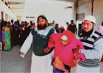  ?? PTI ?? An elderly woman is helped by family members after she cast her vote in assembly elections at a polling station yesterday.