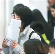  ?? DING TING / XINHUA ?? Left: University graduates attend a job fair in Shanghai early this month.
