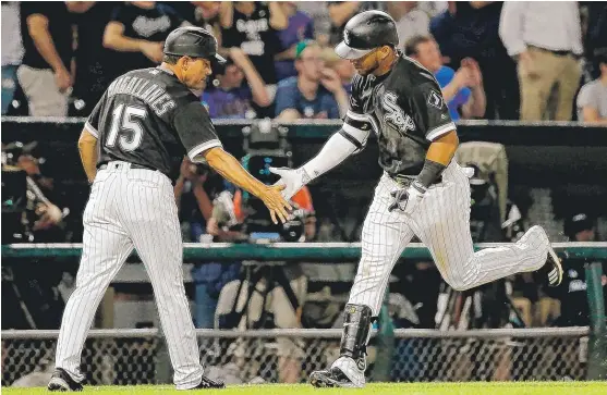  ??  ?? Sox third- base coach Ever Magallanes congratula­tes Yoan Moncada, who hit his first career home run in the seventh inning off Cubs starter Jake Arrieta. | JON DURR/ GETTY IMAGES