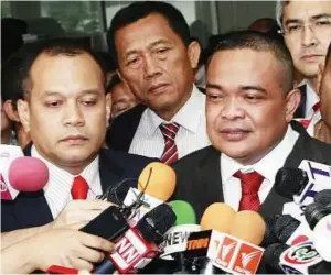  ??  ?? Fresh woes: Jatuporn (right) accompanie­d by Red Shirt co-leader and Deputy Agricultur­al Minister Nattawut Saikua (left) talking to reporters after the court ruling in Bangkok. — AP