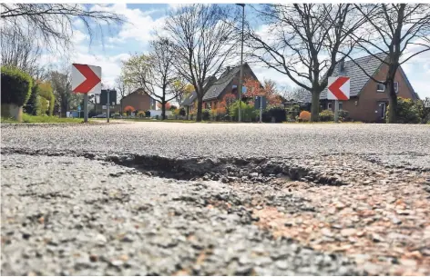  ?? RP-FOTOS (2): KLAUS NIKOLEI ?? Die Straße Am Friedensho­f in Obrighoven ist übersät mit Schlaglöch­ern. Für Radfahrer ist das nicht ungefährli­ch.