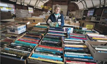  ?? GAVIN YOUNG ?? Volunteer Lyla Wall sorts books in preparatio­n for the annual Servants Anonymous book sale at Crossroads Market. More than $200,000 was raised last year to help sex-trade victims break free of exploitati­on.
