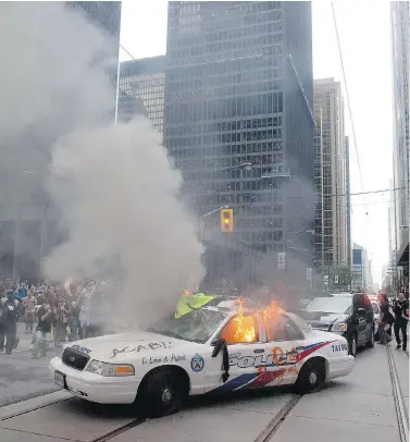  ?? CHRIS YOUNG / THE CANADIAN PRESS FILES ?? A police car burns after G20 summit protesters set fire to it in Toronto in 2010. Two officers who were discipline­d for their actions on that day face a review of their sentences before the Ontario Civilian Police Commission.