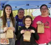  ??  ?? Catherine Sarte, Erin Sarte (back), Noel Mauger and Victoria Mauger of Girl Scout Troop 1134 with their homemade firestarte­r kits.